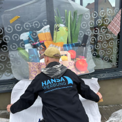 Hansa Werbung Mitarbeiter bringt Folienbeschriftung an